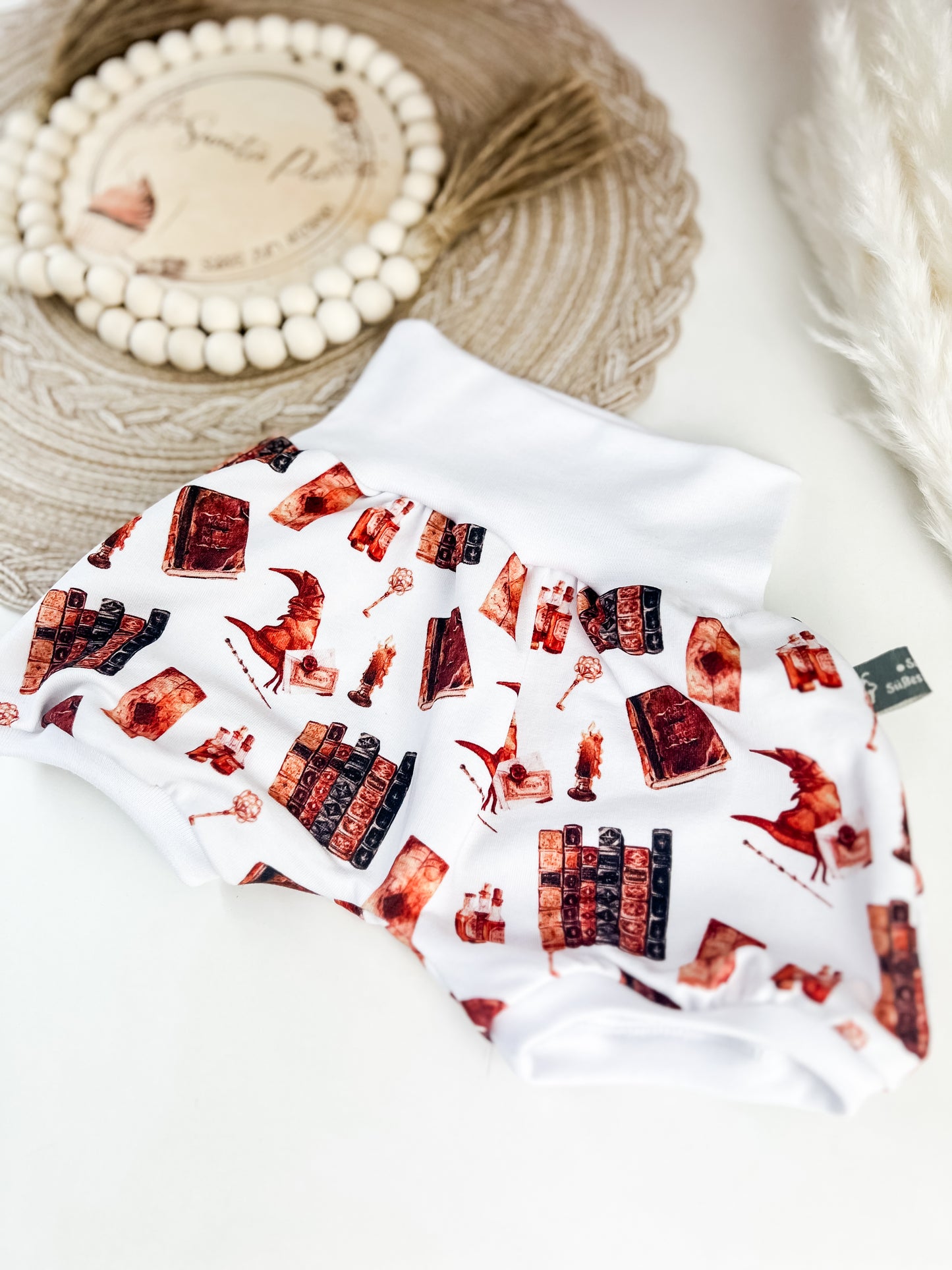Kurze Pumphose Baby Zauberwelt – Weiß mit magischen Motiven – Bücher, Tränke, Hüte & mehr – Handgemacht aus Bio Baumwolle – Gr. 56 - 122 – Mitwachsend & bequem – Geschenk zur Geburt