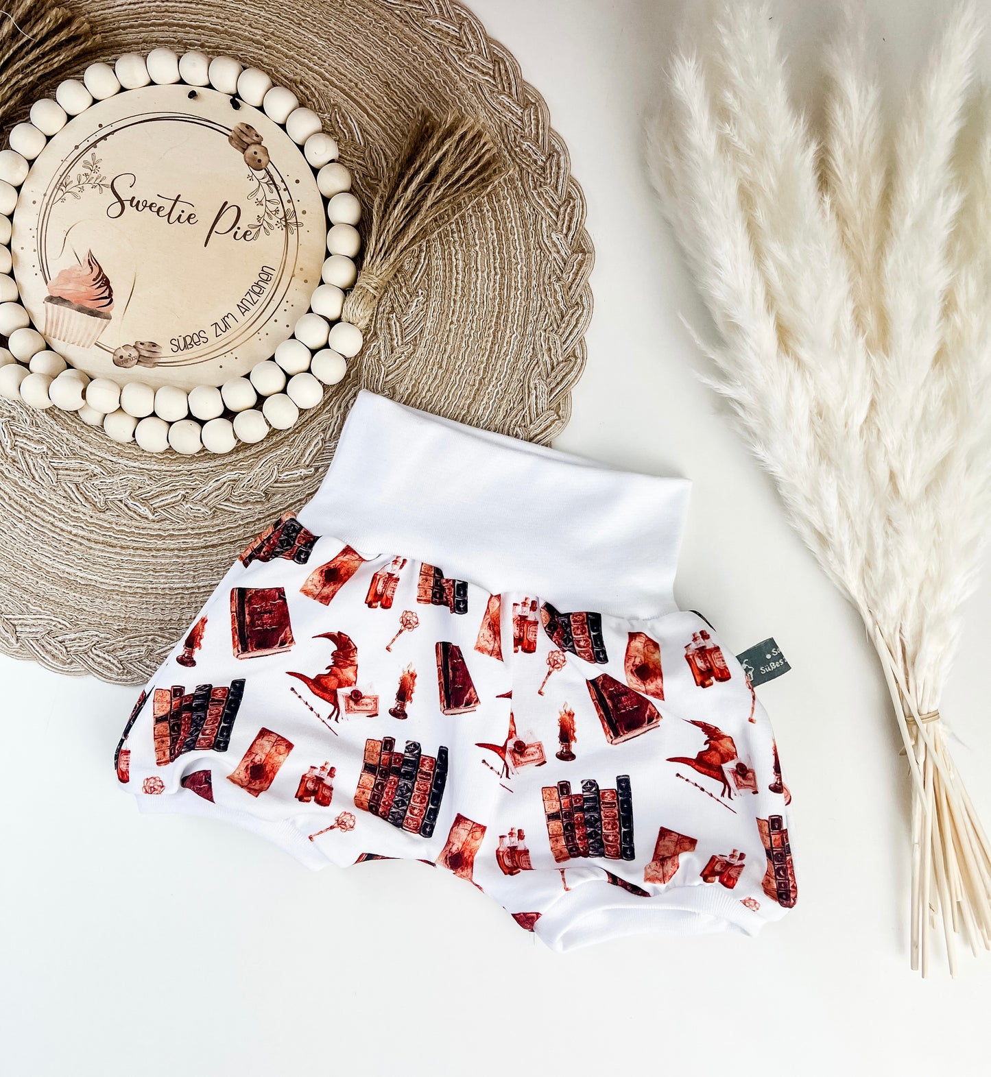 Kurze Pumphose Baby Zauberwelt – Weiß mit magischen Motiven – Bücher, Tränke, Hüte & mehr – Handgemacht aus Bio Baumwolle – Gr. 56 - 122 – Mitwachsend & bequem – Geschenk zur Geburt