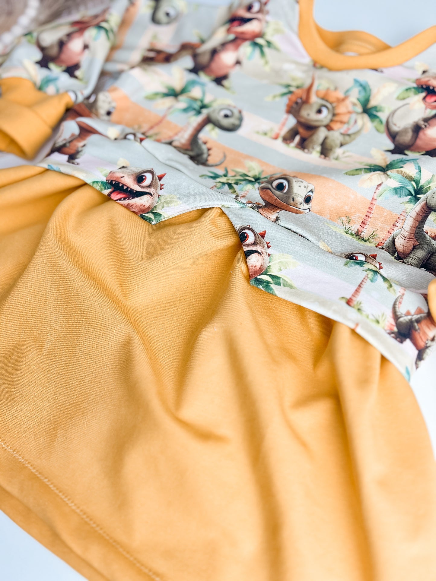 Sweaterkleid für Kinder mit Dinosaurier Motiv – Handgemachtes Mädchenkleid aus Bio French Terry – Gelbes Longshirt mit Dino Print – Kuscheliges Kleid für Herbst & Frühling