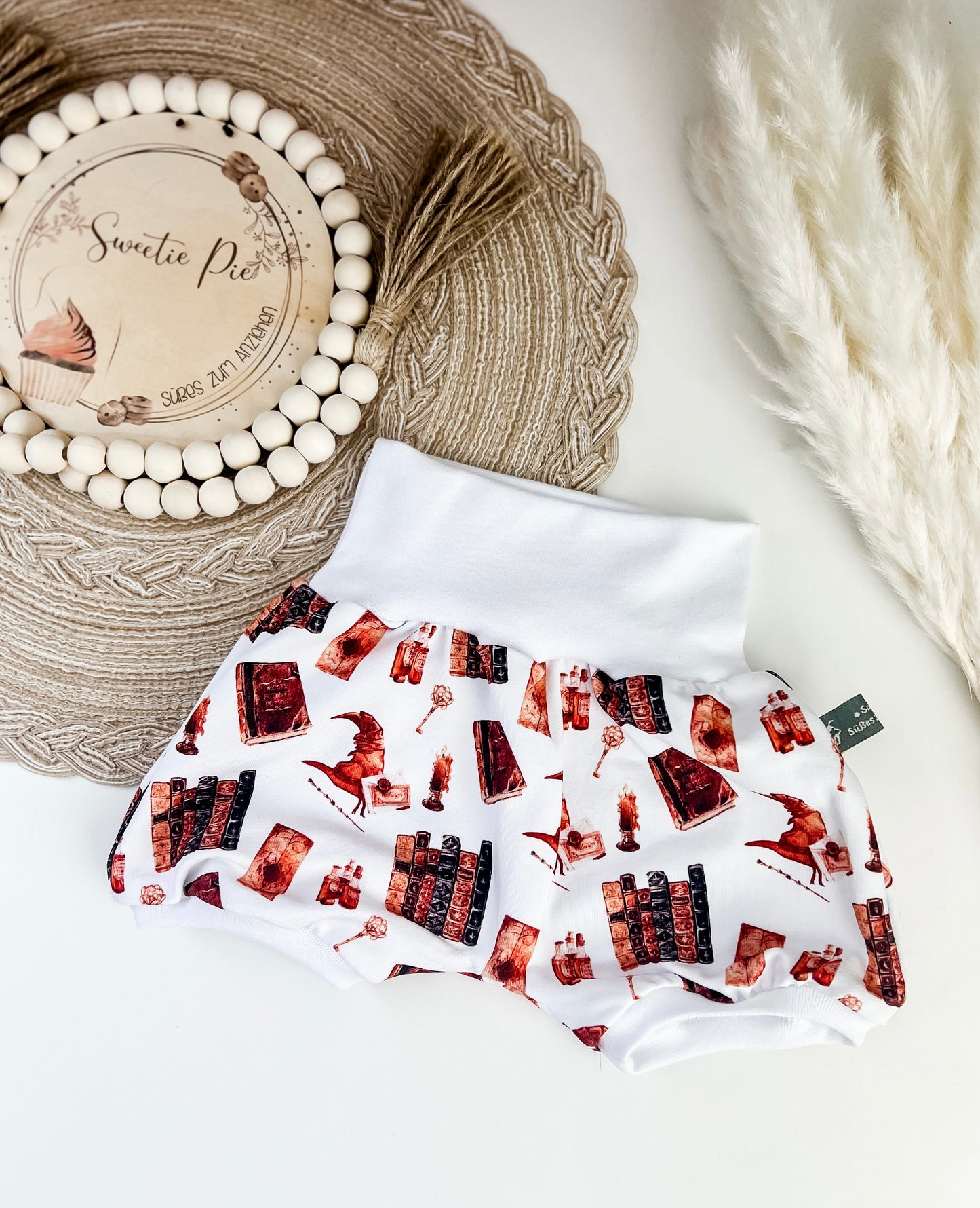 Kurze Pumphose Baby Zauberwelt – Weiß mit magischen Motiven – Bücher, Tränke, Hüte & mehr – Handgemacht aus Bio Baumwolle – Gr. 56 - 122 – Mitwachsend & bequem – Geschenk zur Geburt